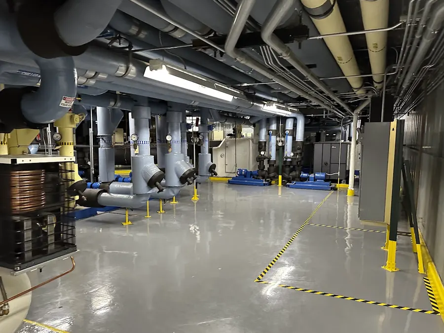 Chilled water distribution piping running the length of the mechanical gallery